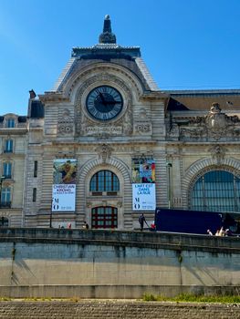 Front view of the historical Musée d'Orsay facade in Paris under a bright blue sky.