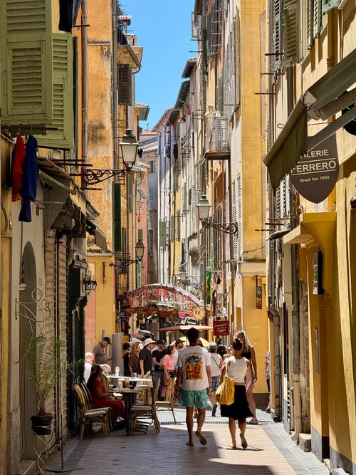 Free Bustling narrow street in Old Nice, France with colorful buildings and tourists. Stock Photo