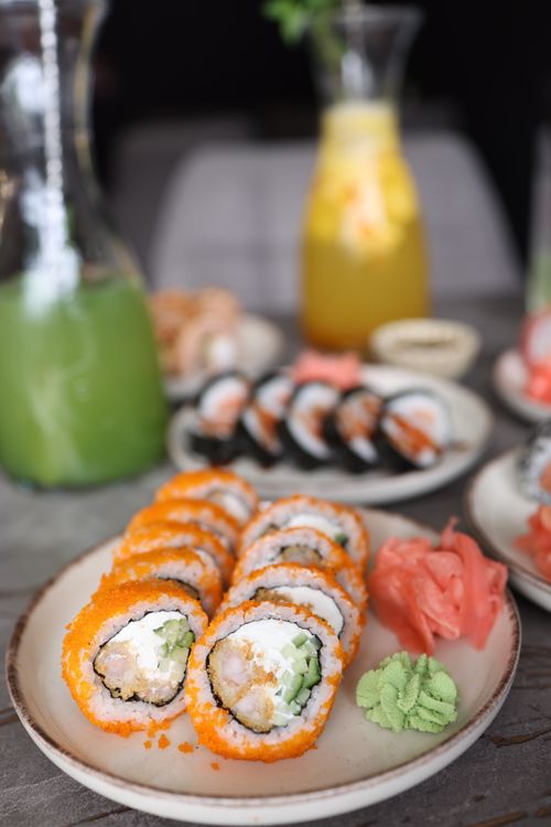 Free Plate of sushi rolls with ginger and wasabi, served with refreshing drinks. Stock Photo