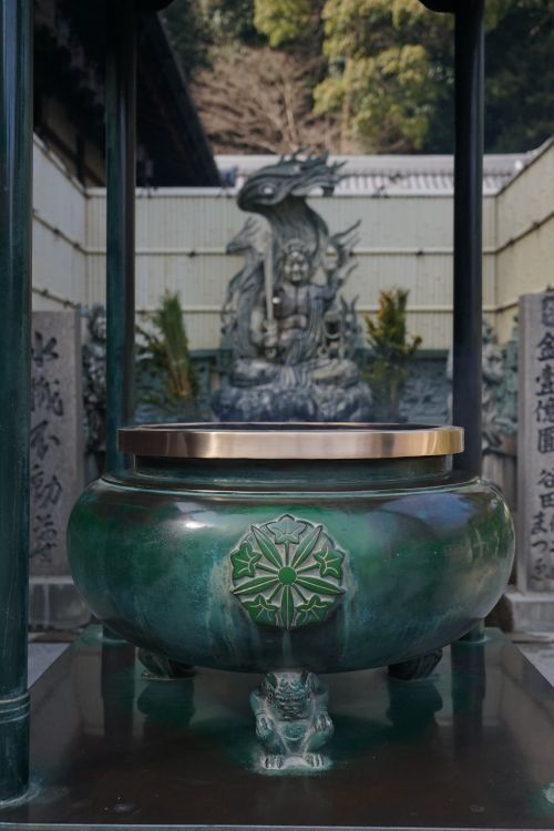Free Green ceremonial incense burner with oriental designs, in a traditional temple setting. Stock Photo