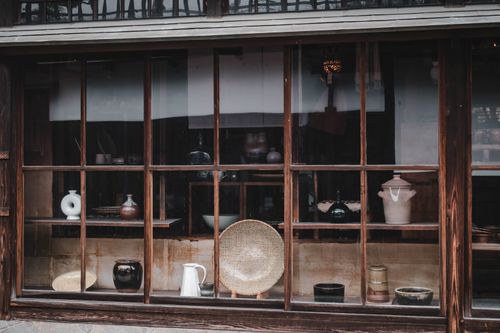 Free Vintage pottery displayed in a traditional Kurashiki shop window, showcasing Japanese craftsmanship. Stock Photo