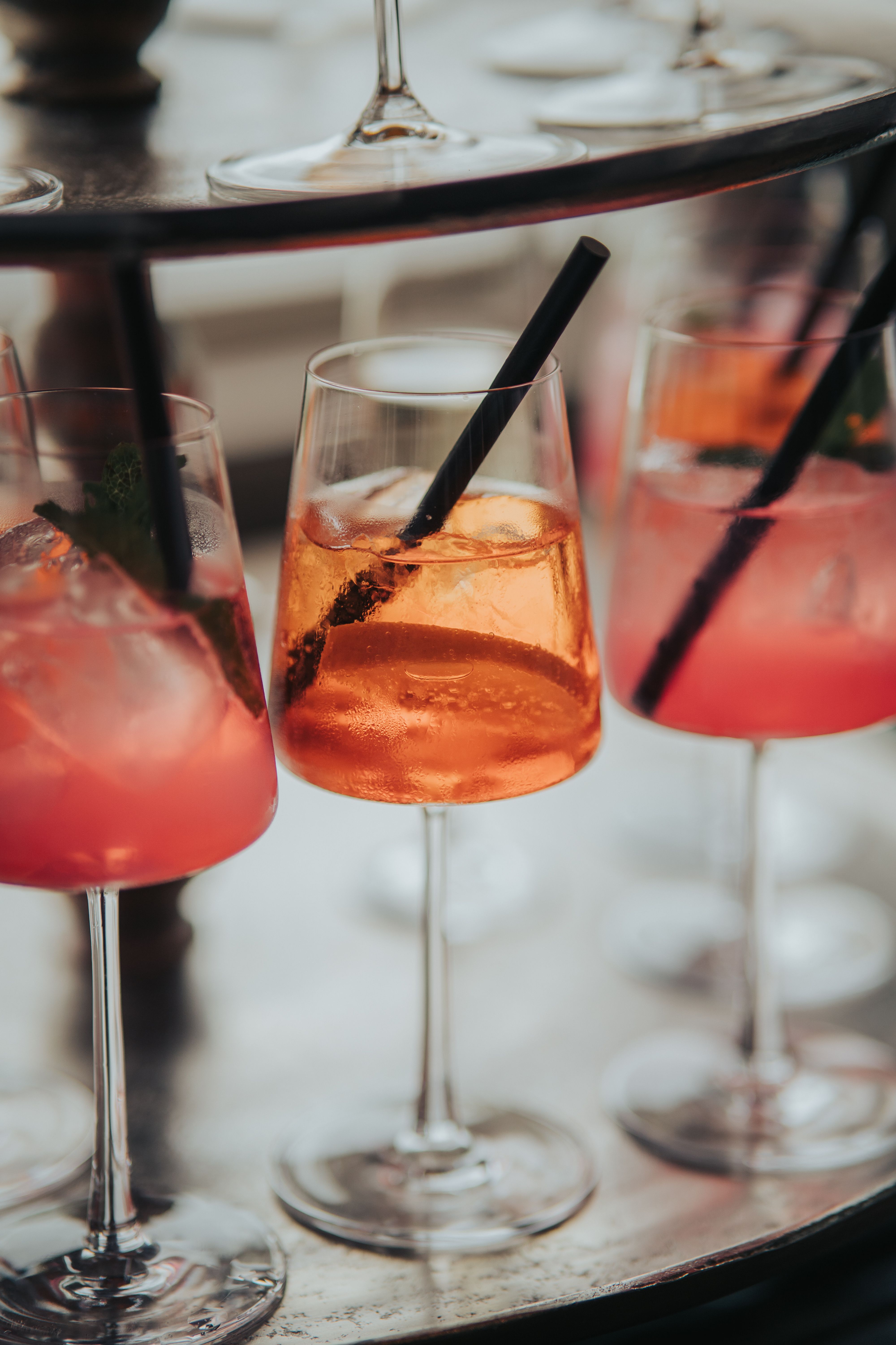 Vibrant cocktails with straws and ice in glasses, perfect for a summer gathering.
