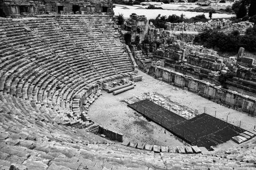 Free Black and white photo of an ancient Roman amphitheater showing its stone seating and historical architecture. Stock Photo