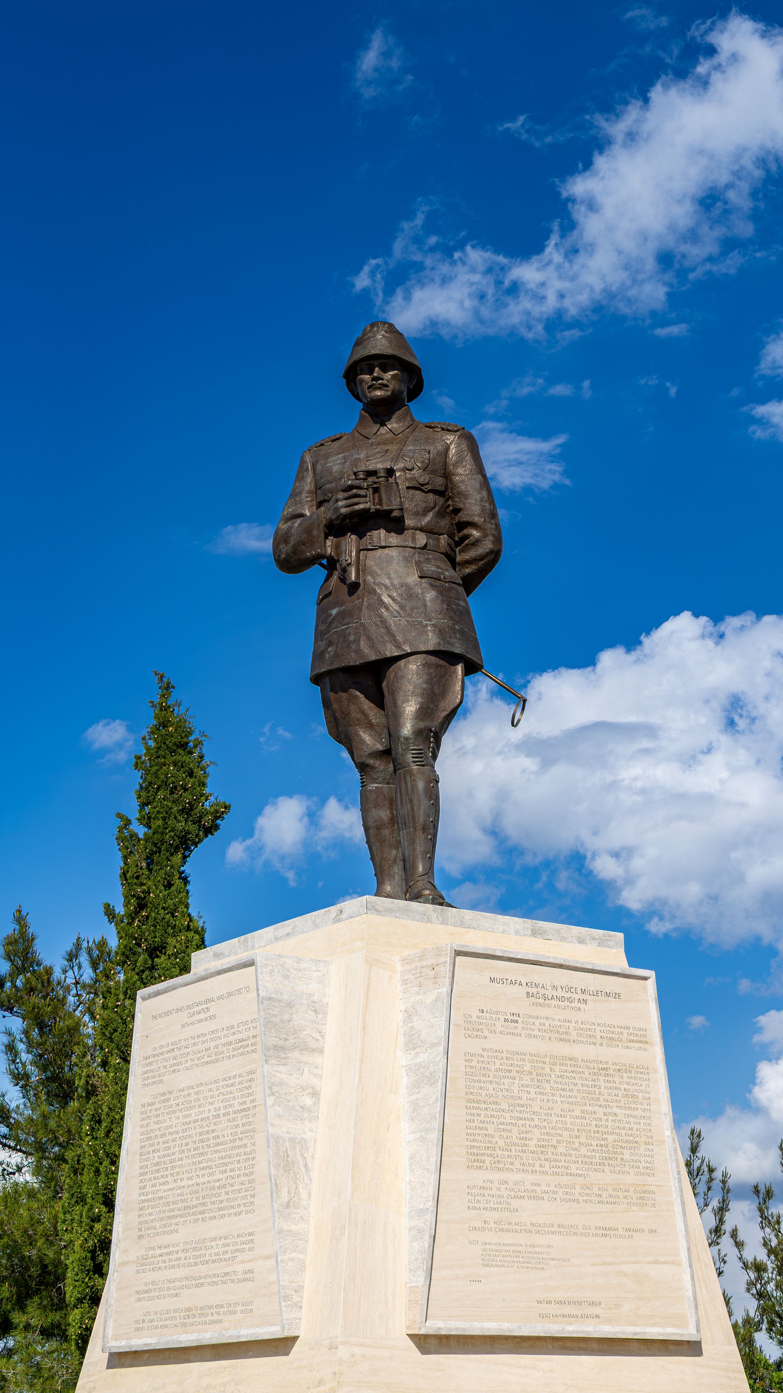 Bronze statue of soldier at Gelibolu, set against blue sky.