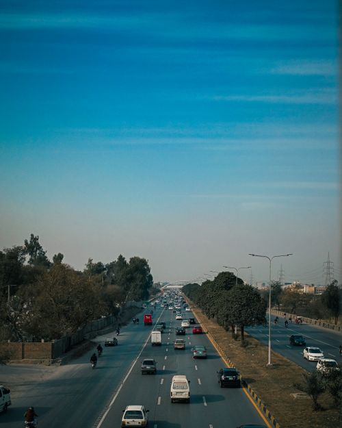 Free A bustling highway scene with vehicles under a vibrant sky, showcasing everyday city life. Stock Photo