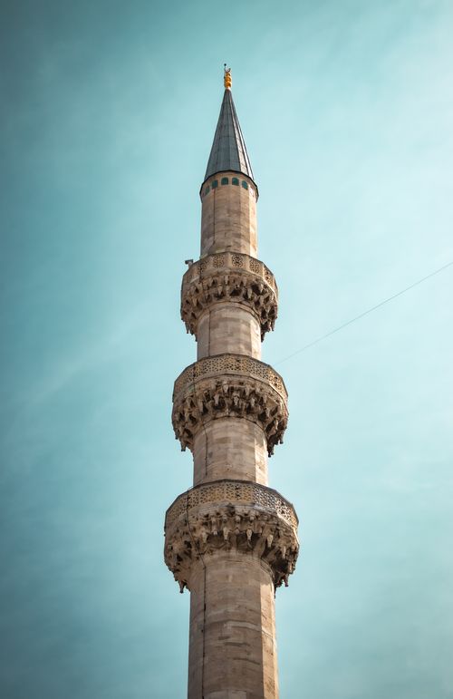 Free Majestic minaret of the historic Eminönü Mosque reaching into the clear blue sky. Stock Photo