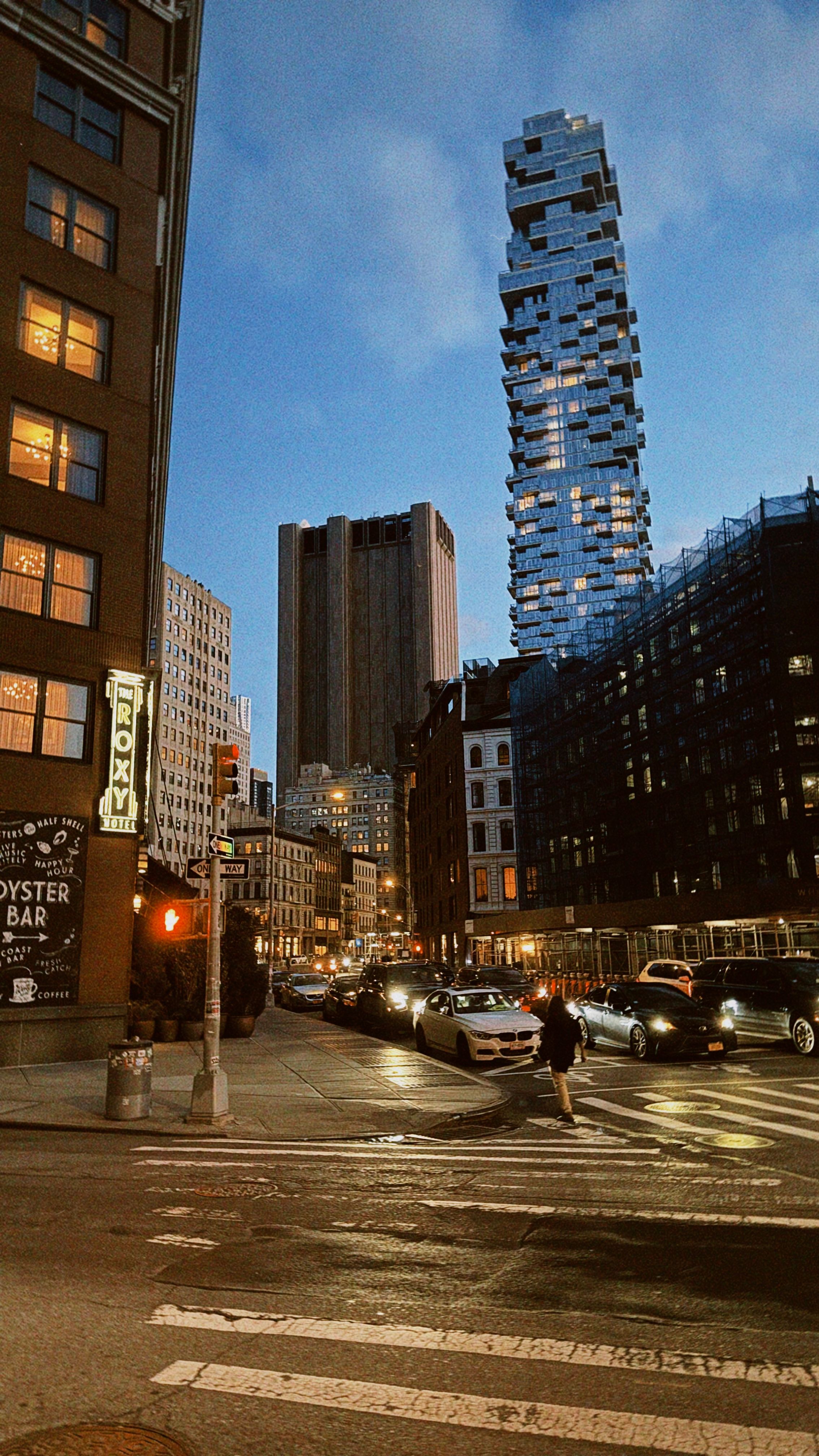 Evening cityscape with traffic and iconic skyscraper in focus. Urban lifestyle captured at dusk.