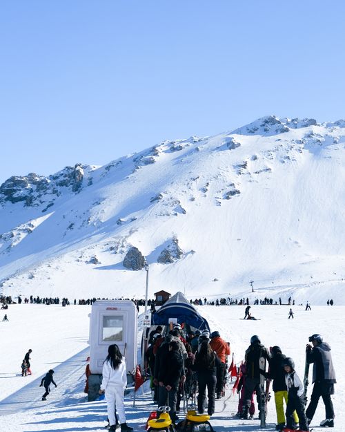 Free Skiers line up at a lift on a snowy mountain in Isparta, Türkiye, under clear skies. Stock Photo