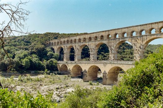 Historic Roman aqueduct Pont du Gard in southern France surrounded by lush greenery.