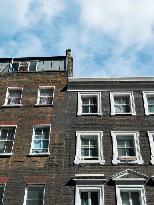 Free A stylish urban scene featuring traditional brick buildings under a clear blue sky. Stock Photo