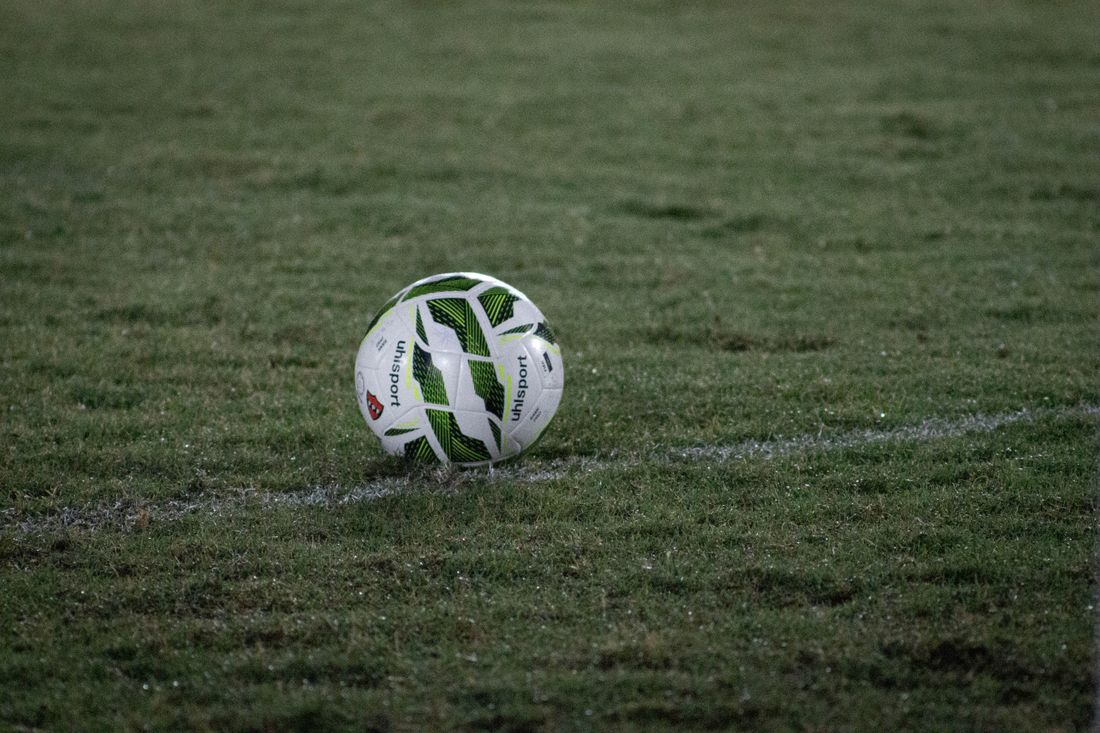 White football on a grass pitch at dusk