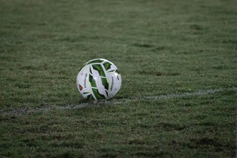 White football on a grass pitch at dusk