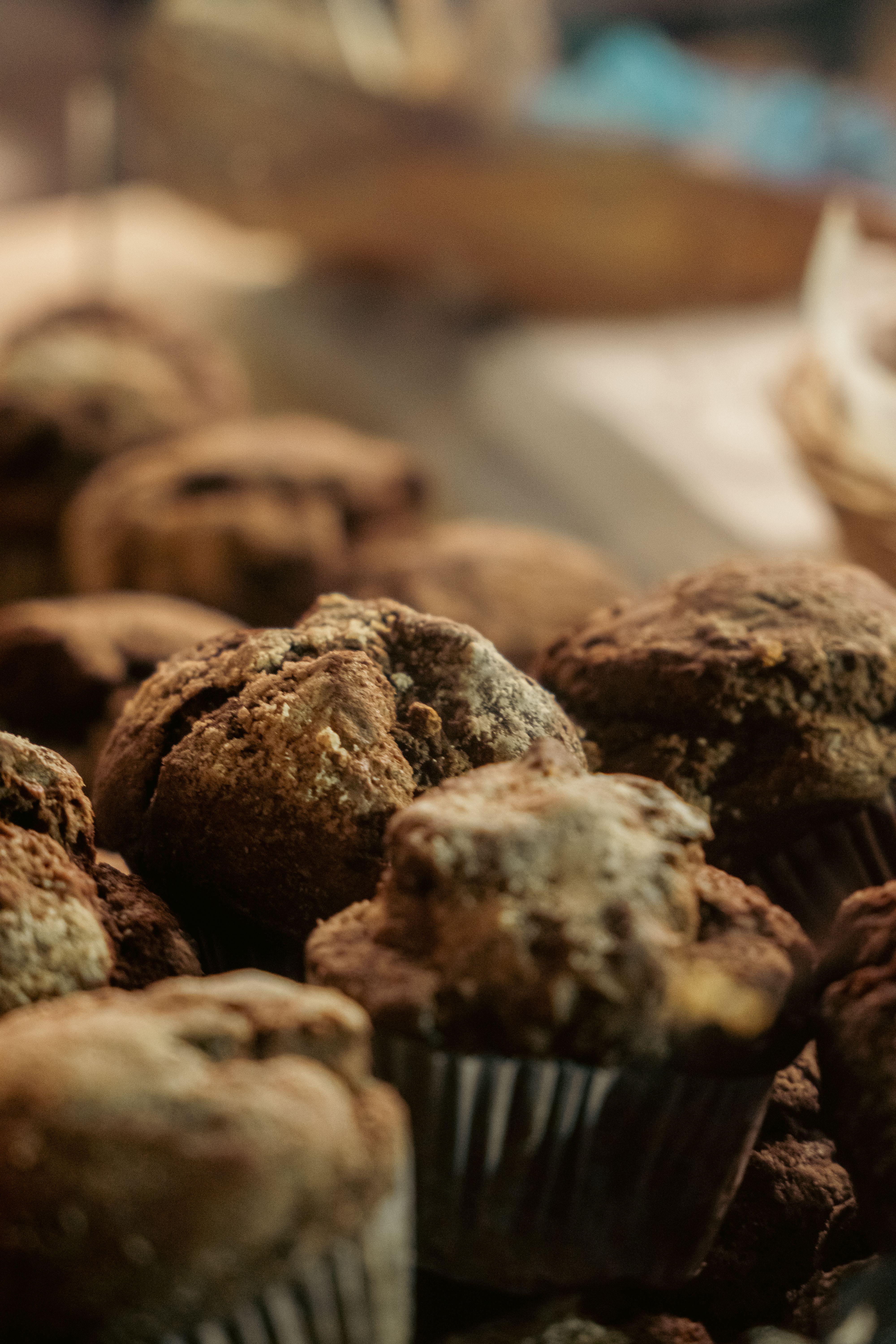 Close-up of freshly baked chocolate muffins with a rustic texture and warm lighting.