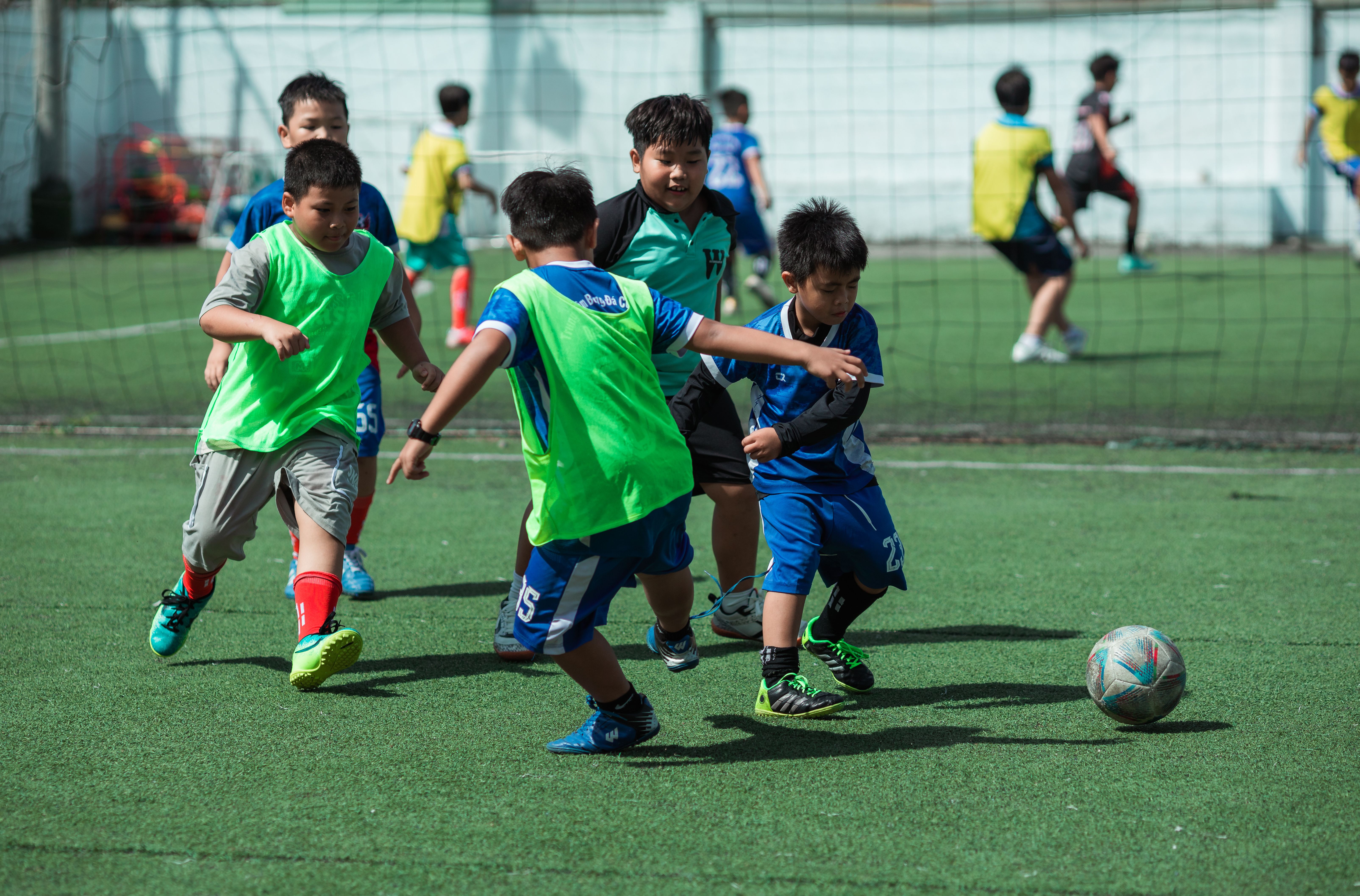 Kids engaging in a soccer match on a sunny day, showcasing teamwork and energy in Vietnam. - Photo by Thái Trường Giang on Pexels