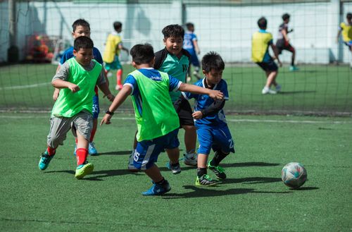 Free Kids engaging in a soccer match on a sunny day, showcasing teamwork and energy in Vietnam. Stock Photo
