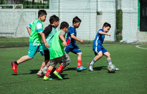 Free Energetic group of boys playing soccer outdoors, showcasing teamwork and action. Stock Photo