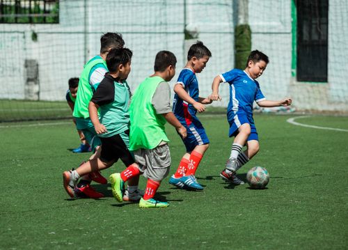 Free A group of boys energetically playing soccer outdoors on a sunny day in Vietnam. Stock Photo