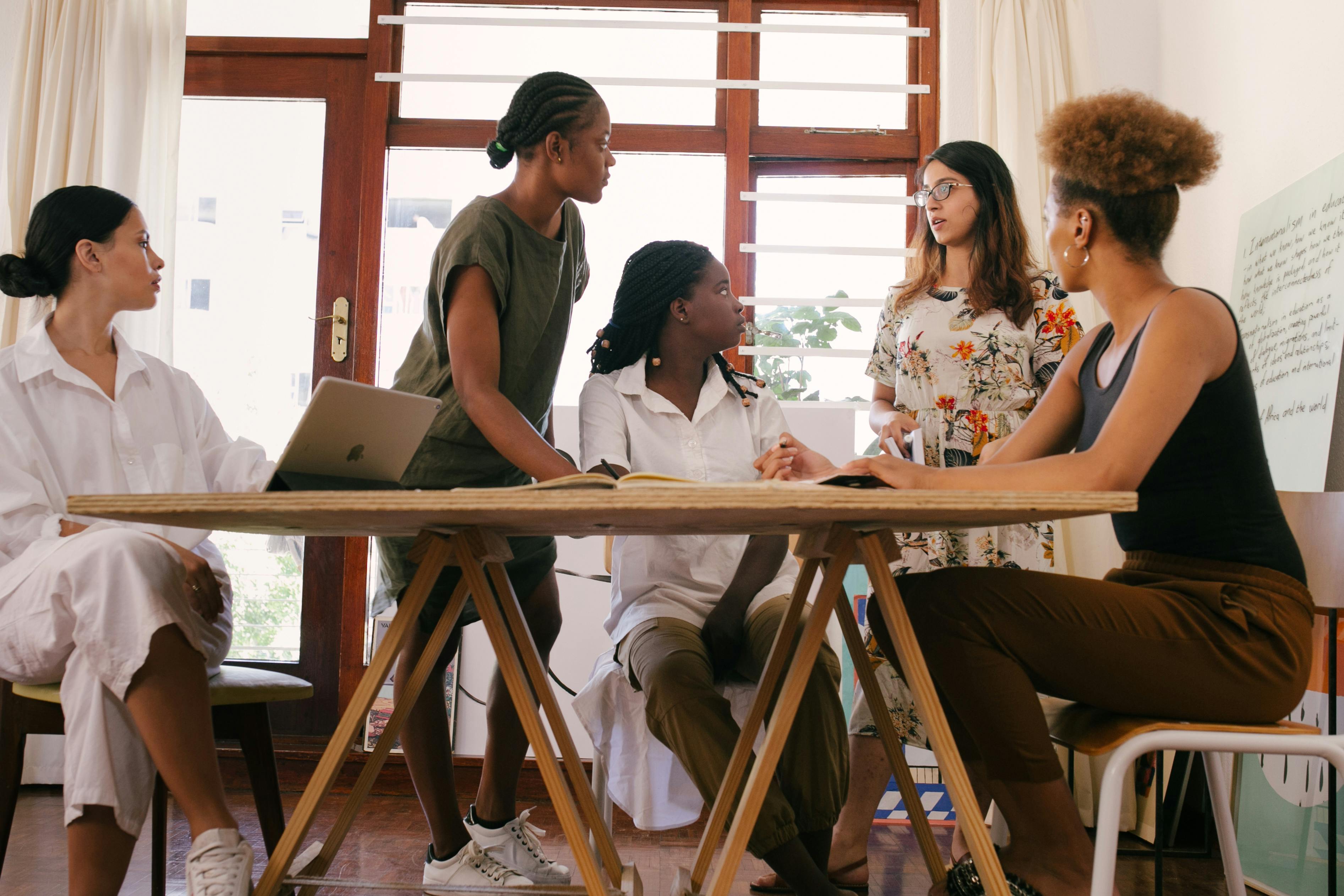 Une équipe diverse collaborant lors d’une réunion hybride, illustrant la nouvelle réalité du management moderne