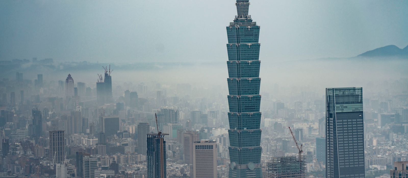 Aerial view of Taipei 101 amidst the urban landscape and foggy skyline in Taipei, Taiwan.