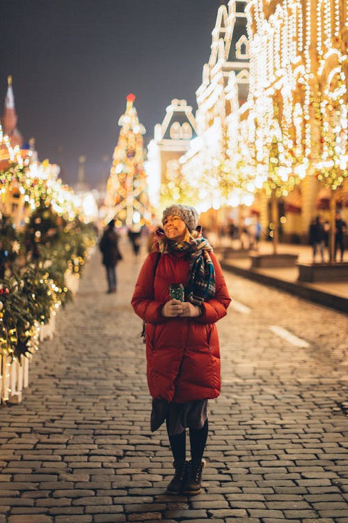 Free Woman in Red Jacket Standing on Pavement Stock Photo