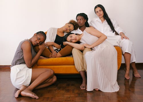 Foto Von Frauen, Die Auf Orangefarbenem Sofa Sitzen