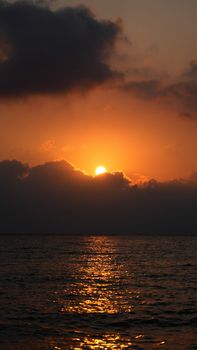 Scenic sunset over the sea in Syria, with vibrant orange and dark clouds creating a dramatic landscape.