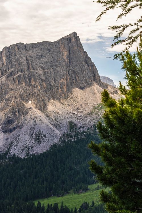 Free Stunning view of a rugged mountain amidst a lush green forest in a serene alpine setting. Stock Photo