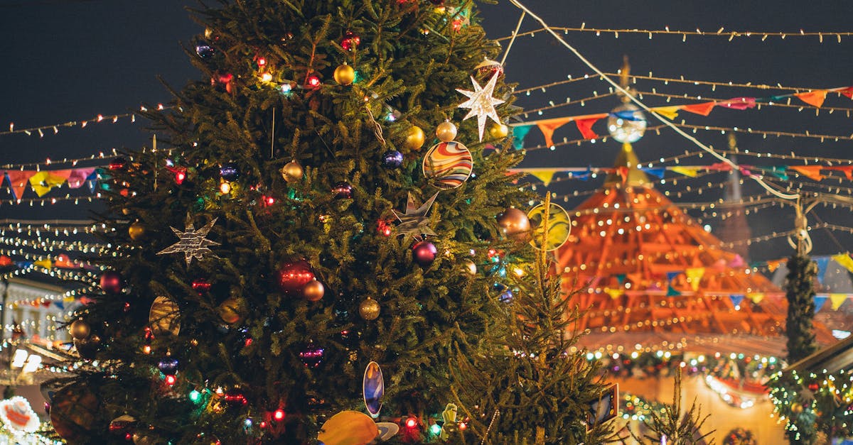 Photo by Elina Fairytale Colorful Christmas decorations light up a festive outdoor market with a beautifully adorned tree.