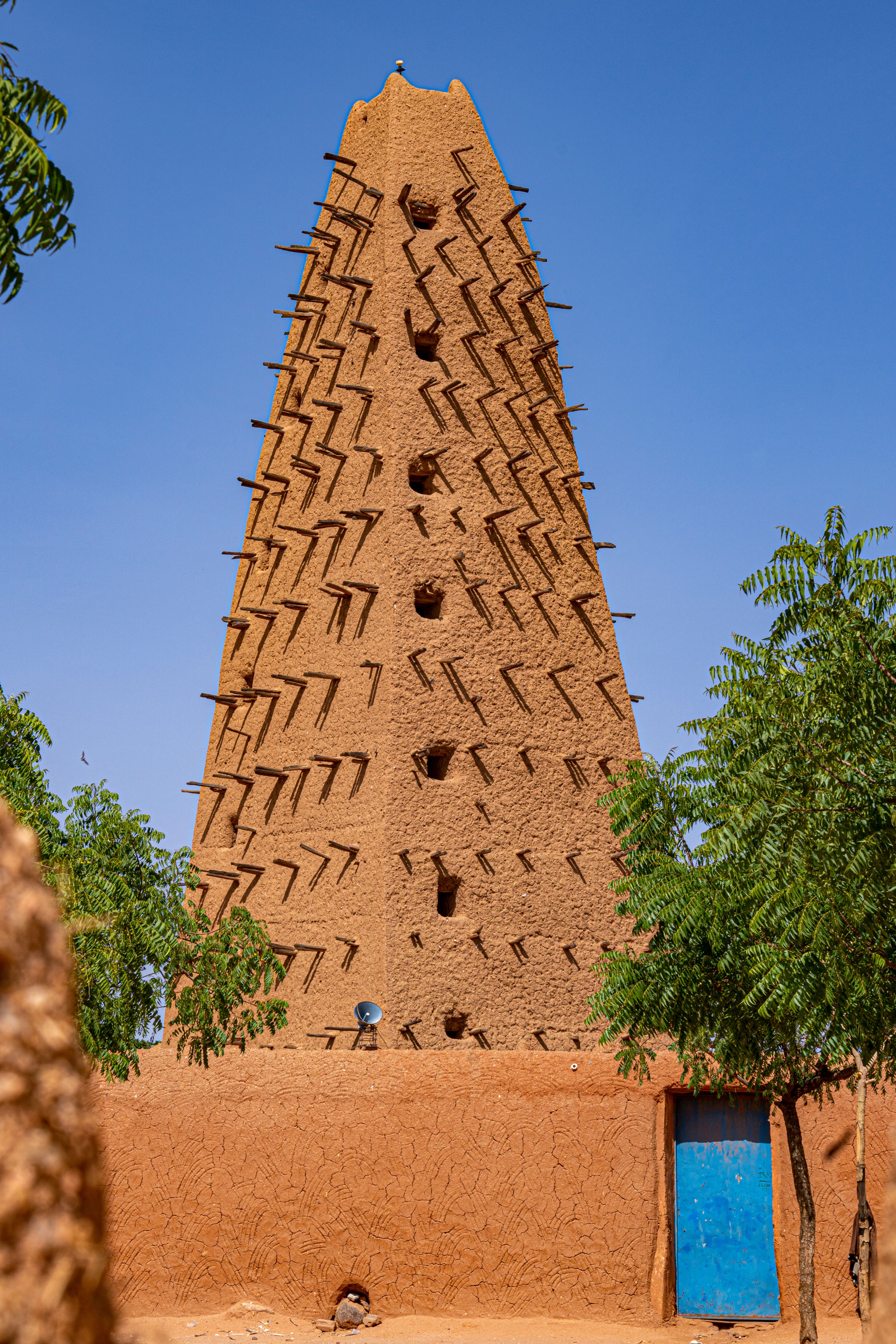 Mud-brick mosque in Agadez, Niger under a clear blue sky.