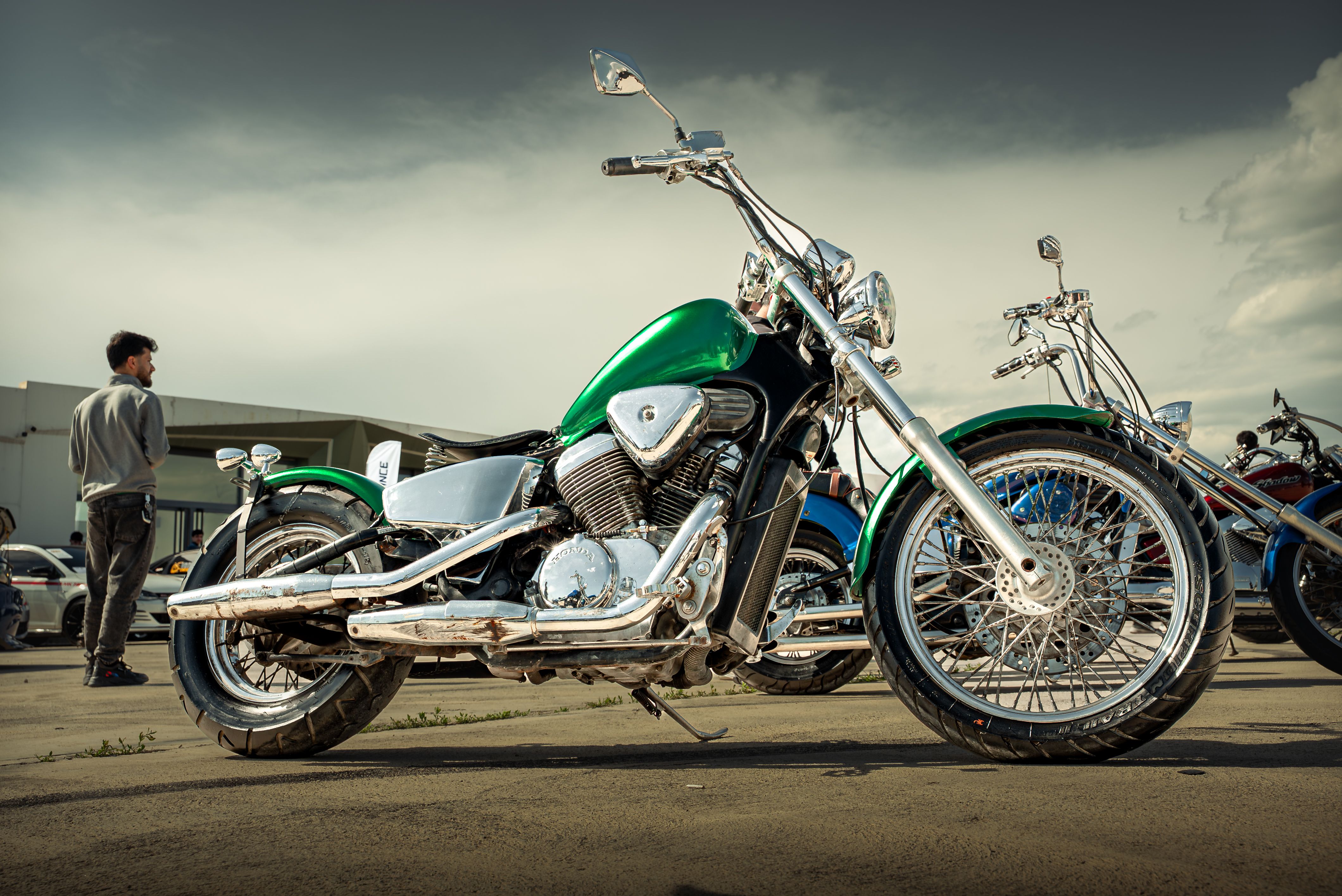 A shiny green motorcycle parked outdoors in Sulaymaniyah, Kurdistan Region, Iraq during daytime.
