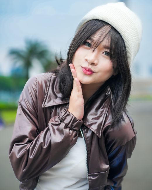 Stylish young woman poses outdoors in Jakarta, Indonesia.