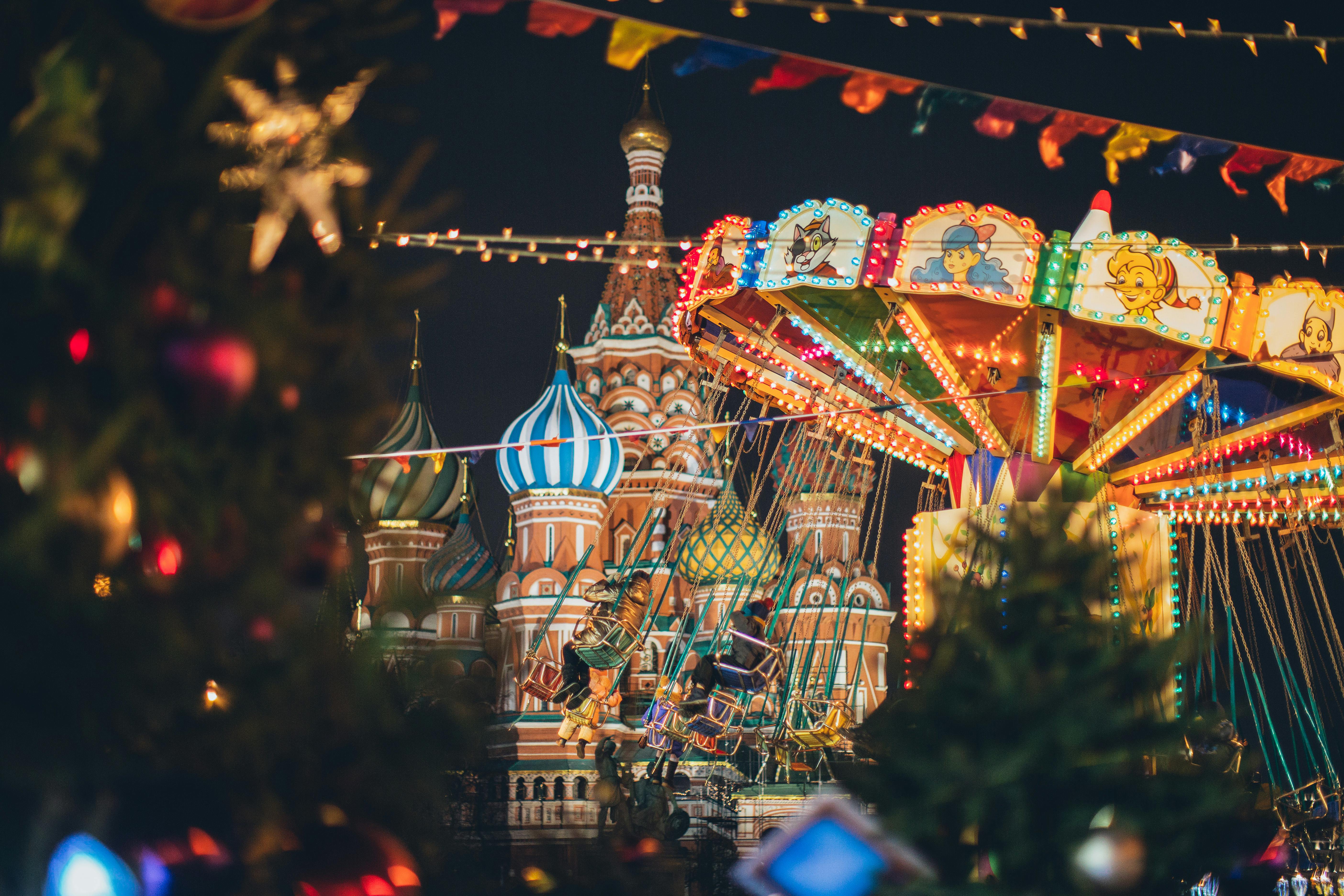 colorful carousel against cathedral on red square at new year night