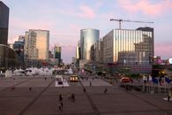 Capture of La Défense, Paris, with skyscrapers and pink sunset skies.