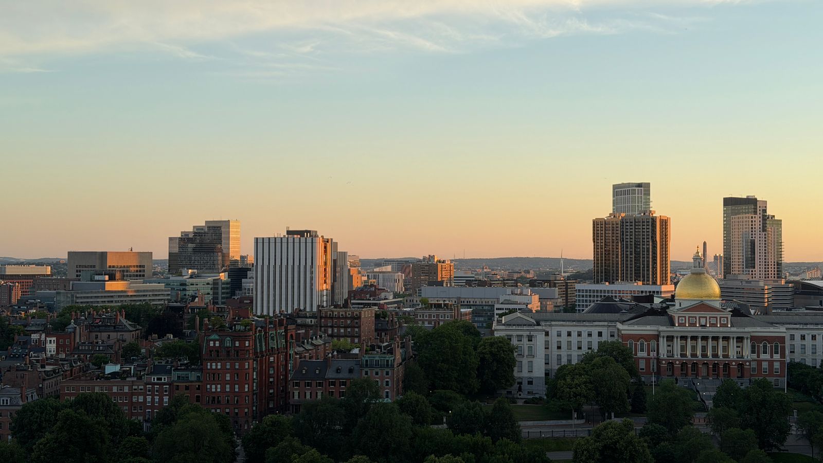 Aerial view of the Boston skyline during sunset, highlighting the Massachusetts State House in Boston, MA.