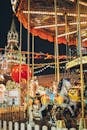 Festive merry go round with carnival horses on Red Square against blurred Kremlin during New Year holidays in evening