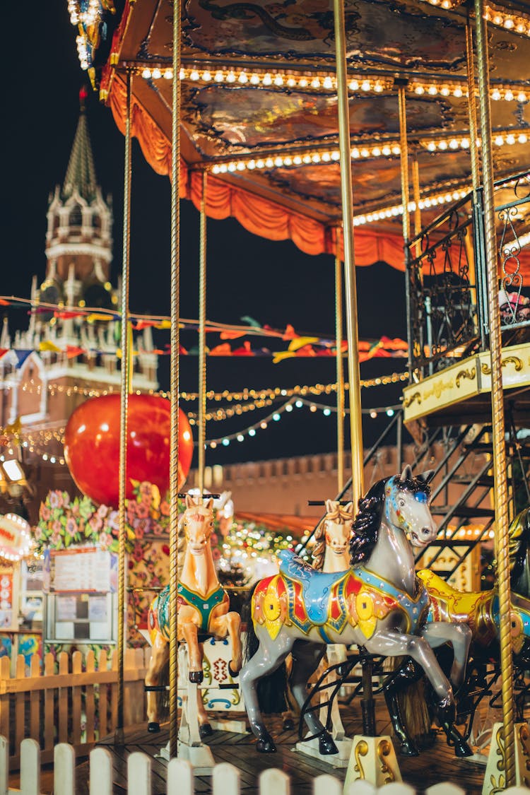 Colorful Carousel With Fabulous Ponies In Amusement Park At Night