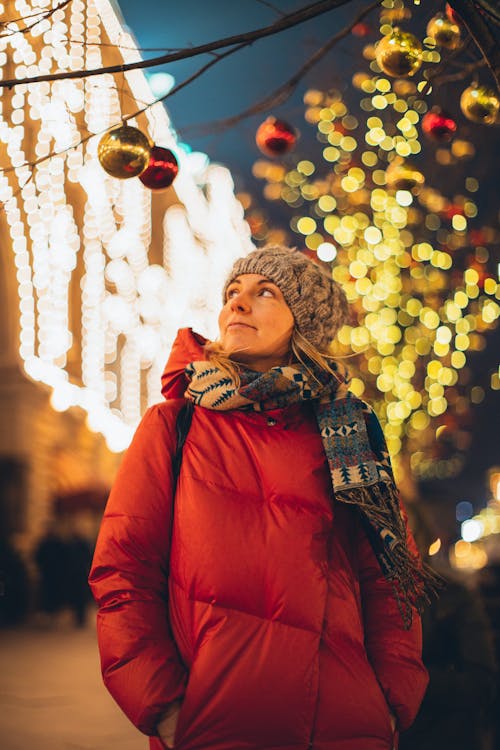 Smiling woman in city decorated for Christmas