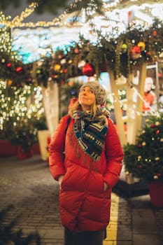 穿着冬装的女人在夜晚的圣诞市场里，欣赏着节日的灯光和装饰