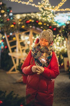 节日灯光下，一位身穿冬装的女子手持烟花，面带微笑