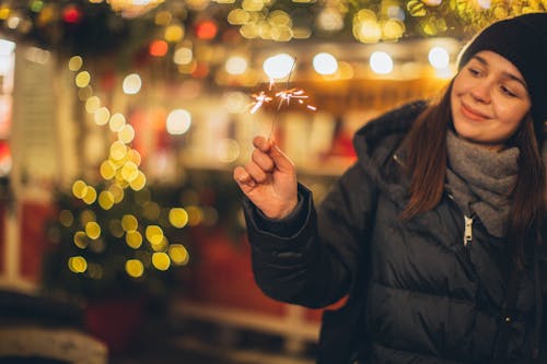 Wanita Dengan Jaket Hitam Memegang Kilau Menyala