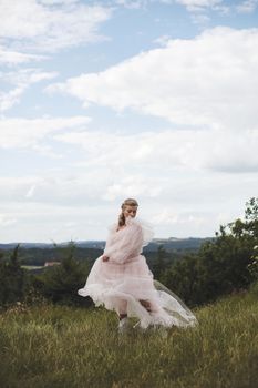 Serene portrait of a woman in a flowing pink dress outdoors in Zakopane, Poland.