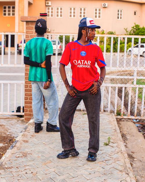 Free Two young adults showcase trendy street fashion with sports jerseys in an outdoor setting. Stock Photo