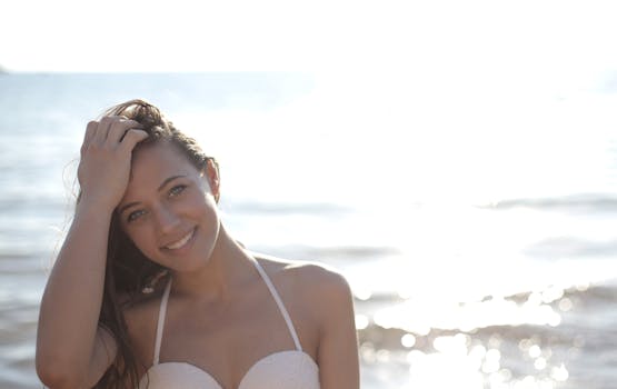 一位快乐的女子穿着比基尼，在海滩上笑容灿烂地享受着阳光明媚的一天