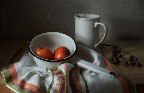 Free A rustic still life featuring persimmons with vintage tableware on a cloth. Stock Photo