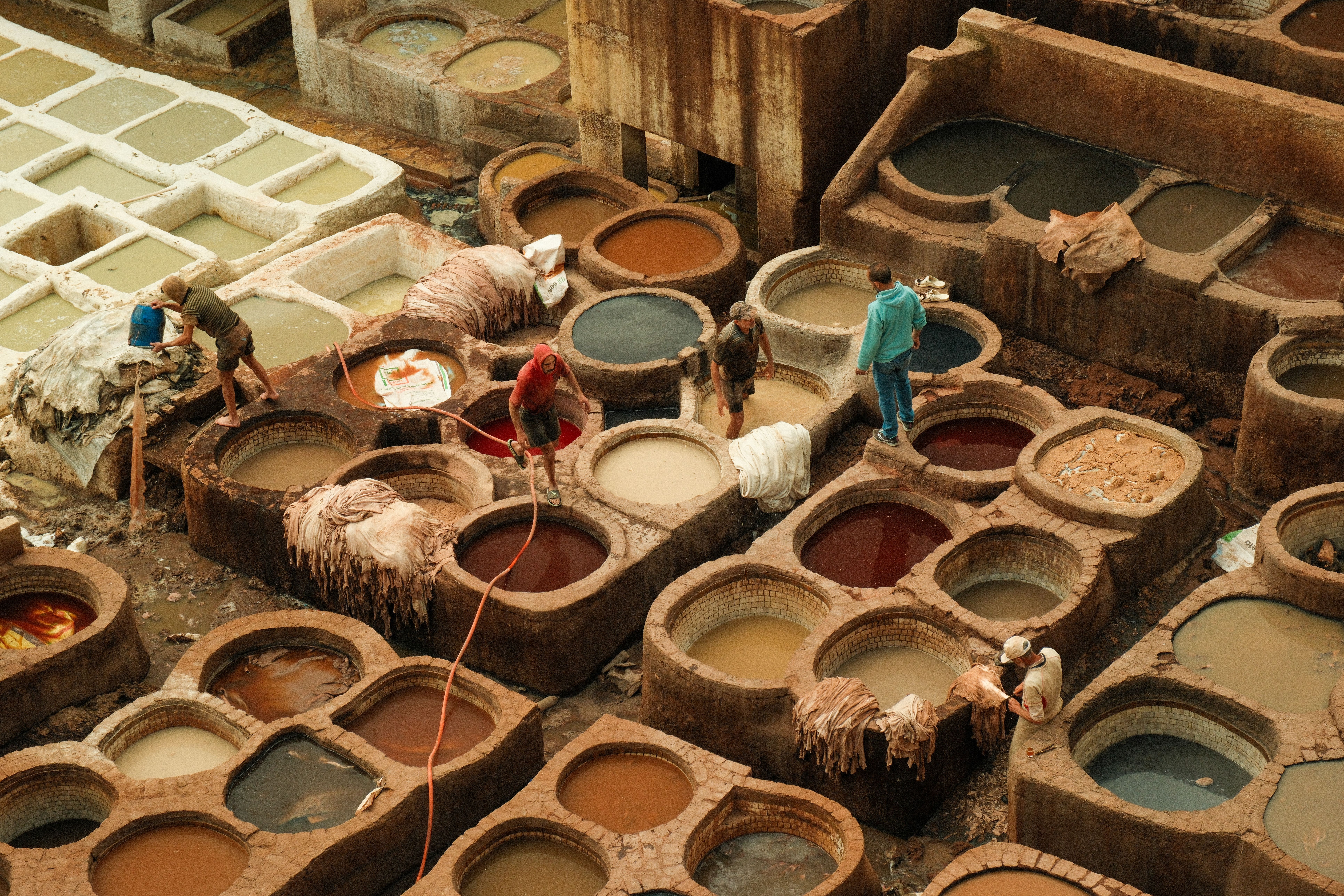 Bird's-eye view of traditional leather tanning pits in Fes, Morocco, showcasing vibrant colors and craftsmanship.