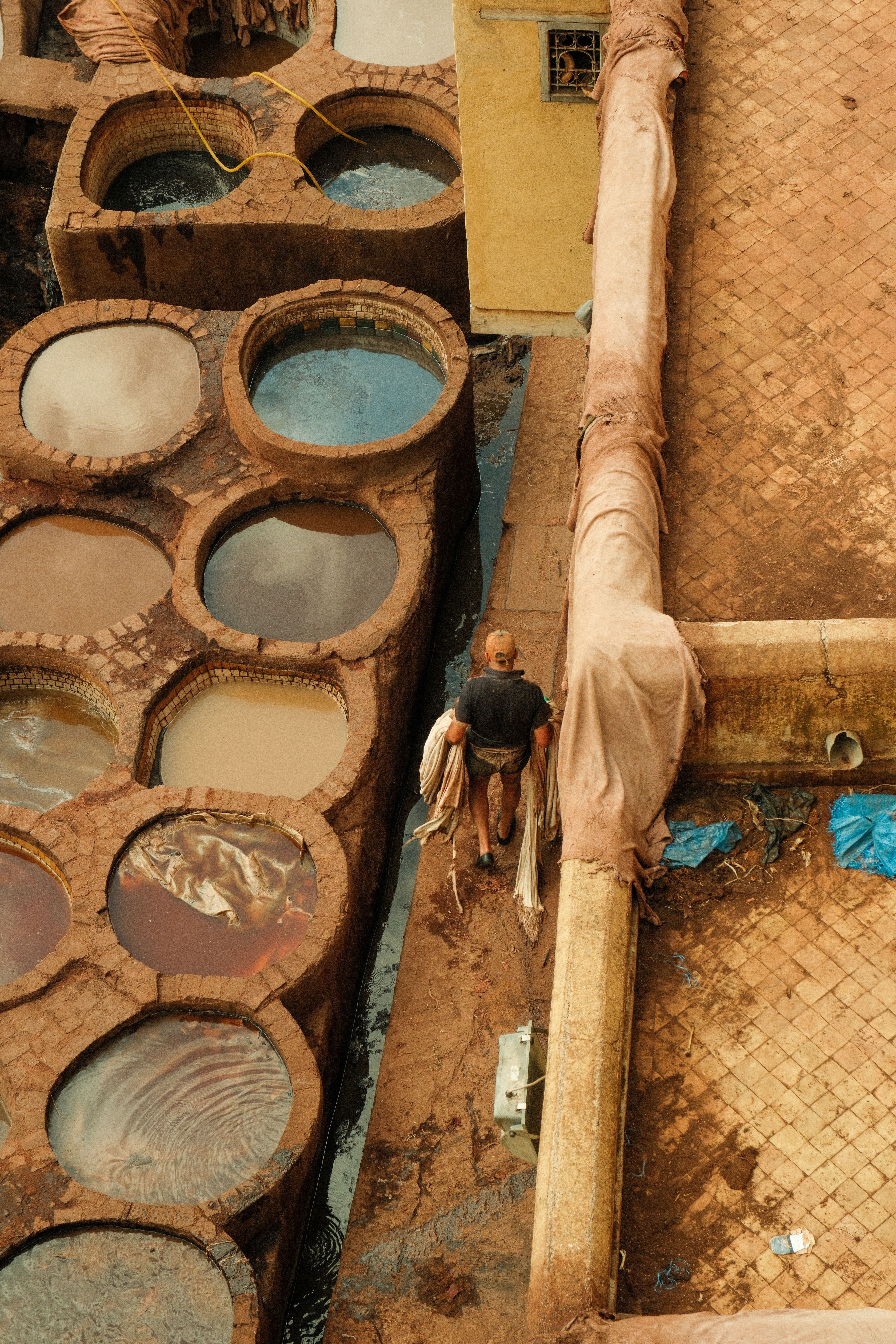 Man working in a traditional tannery in Fes, Morocco, showcasing ancient leather processing techniques.