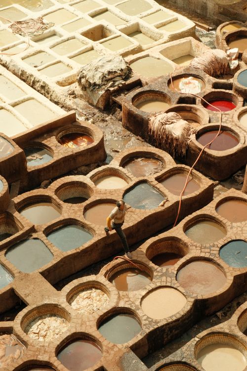 Free Aerial view of a traditional tannery in Fes, showcasing colorful dye vats and leather processing. Stock Photo