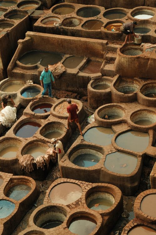 Free View of the ancient dye pits at Fes Tannery, showing artisans at work. Stock Photo