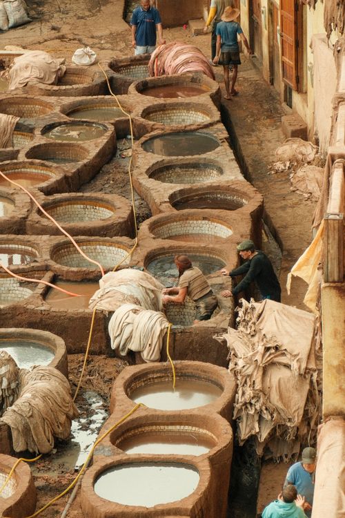 Free Aerial view of workers at Chouara Tannery in Fes, Morocco, with traditional dyeing pits. Stock Photo