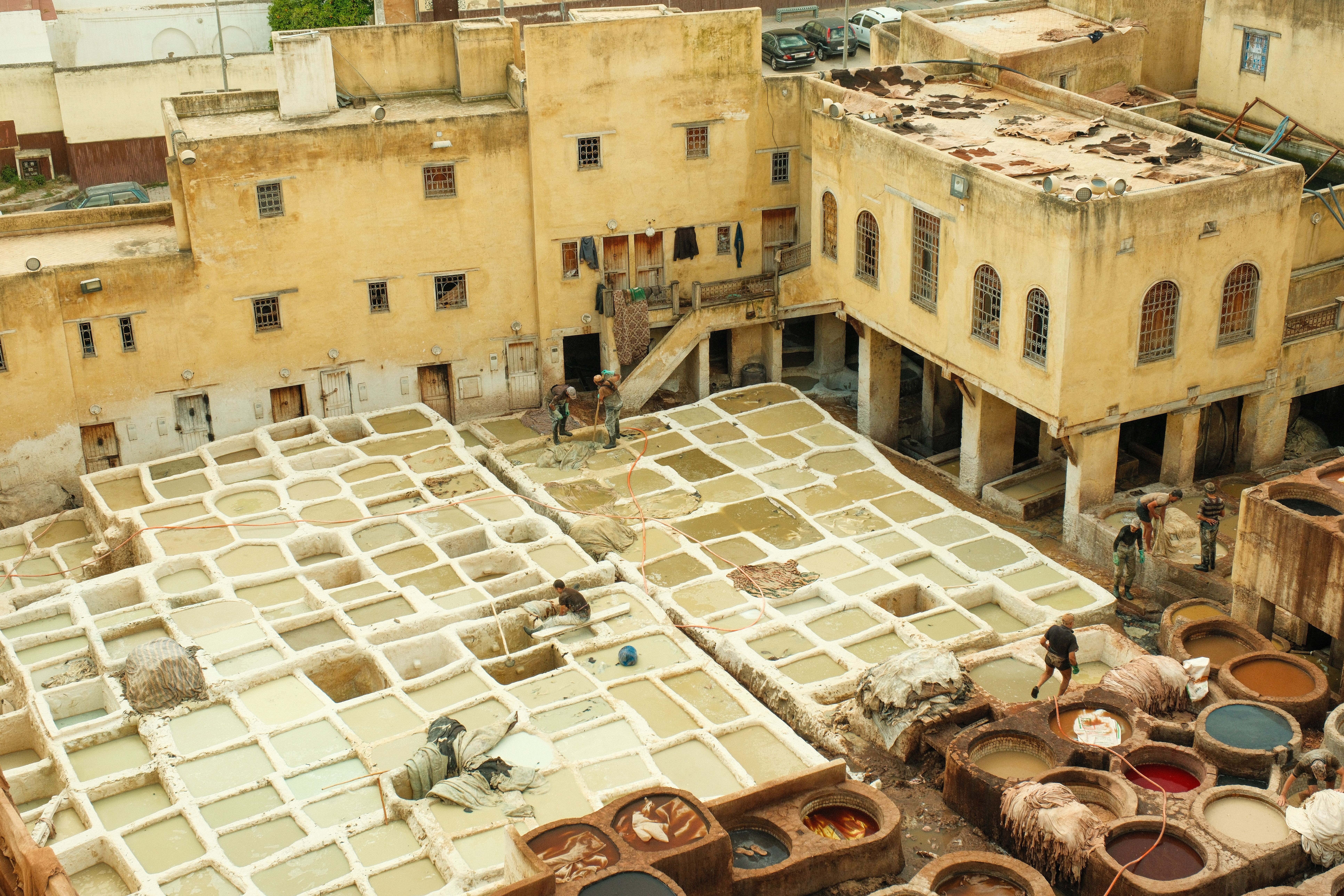Aerial view of iconic leather tanneries in Fes, Morocco. Showcases traditional methods.